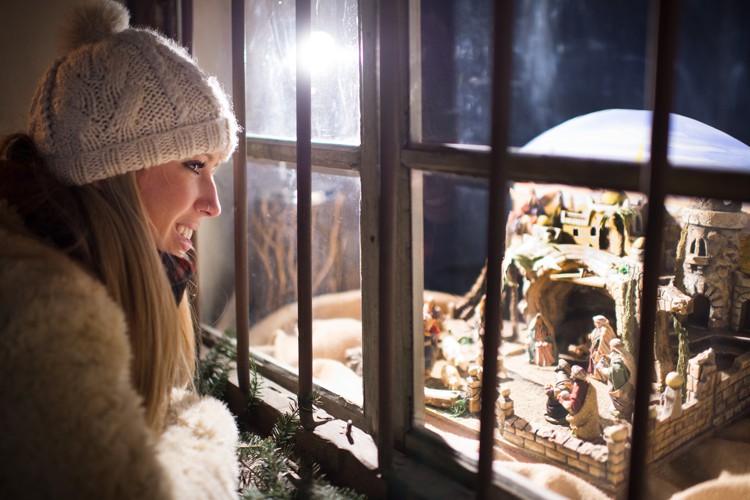 Una donna guarda un presepe