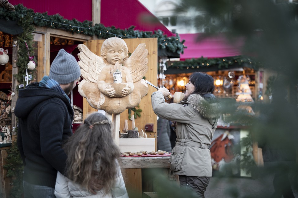 Una donna scolpisce un angelo di legno